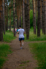 Young man running early in the morning. Sport active concept photo. Tracking Park. Russia. 01.07. 2020 