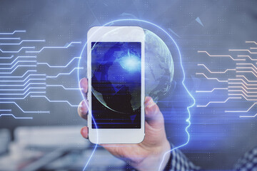 Double exposure of man's hand holding and using a digital device and brain hologram drawing. Data concept.