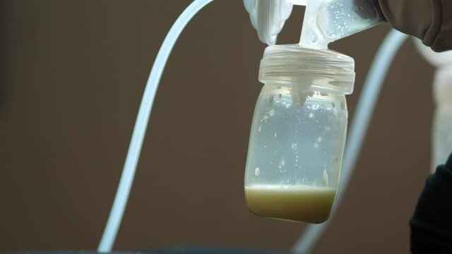 Mom use electric breast pump feeding for her baby.