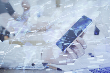 Double exposure of man's hand holding and using a digital device and data theme hologram drawing. Technology concept.