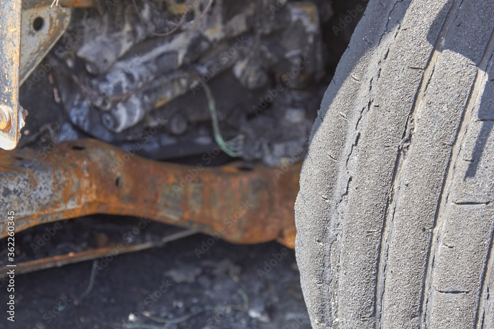 Wall mural wheels and wheels of a burned-out car in one of the city's districts selective focus