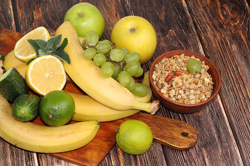 Vegetables, fruits and granola on a dark background. The concept of healthy and natural food for weight loss, lifestyle, detox diet, the purpose of which is to eliminate carbohydrates 
