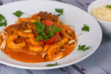 Pasta spaghetti with tomato sauce and seafood. On rustic background