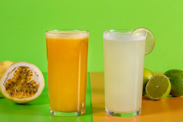 tropical fruit juices on green background. Lemonade and passion fruit juice with fruits in the background