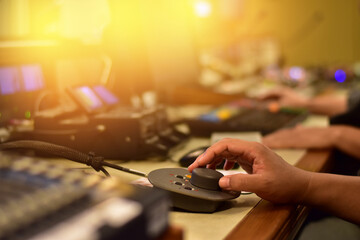 hand moving sliders on audio mixing board