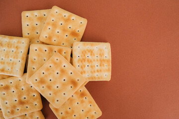 Heap of crackers on brown background. Snacks concept.