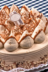 Pastel de cajeta con Pan de almendra humectado en tres leches relleno, cubierto y decorado con crema de queso con cajeta y espiral de cajeta con nuez espolvoreada.