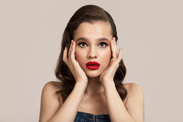 Portrait of beautiful surprised pin-up girl on gray background.