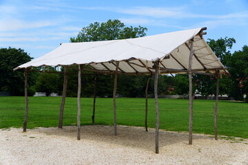 A large tent made with white cover and tree branches