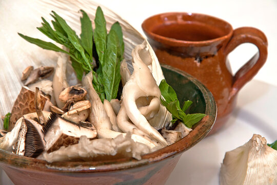 Sopa de hongos servido en plato y jarro de barro con sus ingredientes	