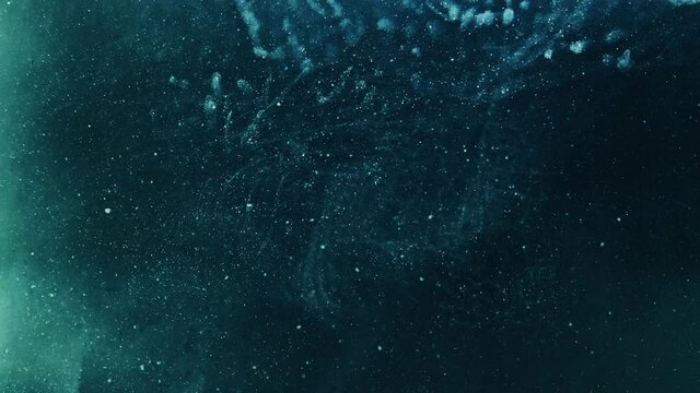 Glitter abstract background. Cosmic dust. Teal blue sparkling smoke hypnotic motion.