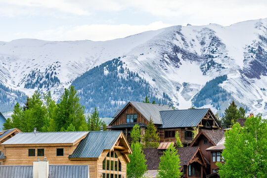 Mount Crested Butte, Colorado village in summer morning with hilldside houses on hills and Aspen green trees closeup