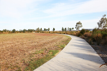 Housing estate located in Clyde North, near Berwick, Victoria featuring lake surrounded by plants...