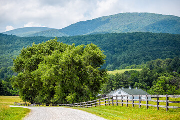 Farm house gravel road wooden fence path in Roseland, Virginia near Blue Ridge parkway mountains in...
