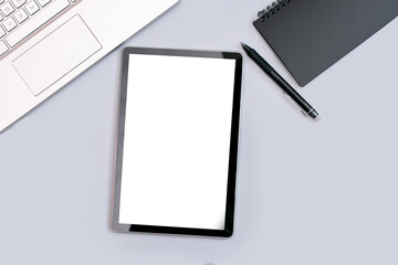 business photos of a tablet with a place to insert, a laptop and a black Notepad on a gray background, top view