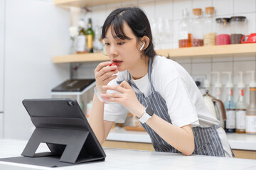 Pure girl using tablet computer in kitchen

