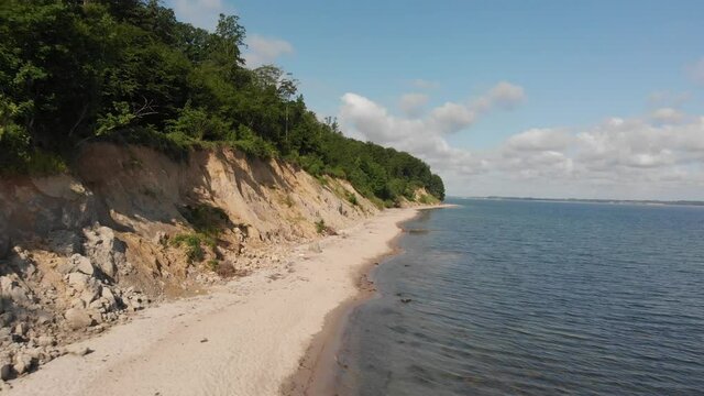 Beautiful beach in northern Germany, Schleswig-Holstein called Noer Beach on the Baltic Sea.
Holiday in Germany.
Drone flies backwards next to the cliff.