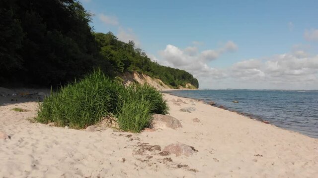 Beautiful beach in northern Germany, Schleswig-Holstein called Noer Beach on the Baltic Sea.
Some garbage on the beach
Drone flies forward at a low altitude next to the cliff.