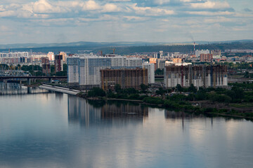 Obraz premium The construction of multi-storey buildings on the banks of the river.