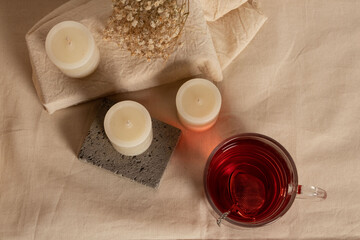Fototapeta na wymiar Espacio ambientado para meditar, con velas, té rojo y flores, con espacio para poner texto