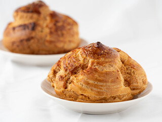 Homemade profiteroles with cream,isolated on a white background. Fresh baked golden profiterole. Custard cake.