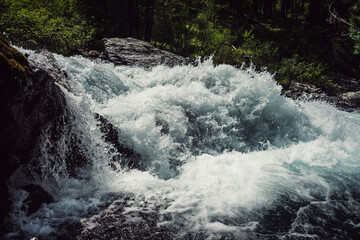 Big rapids of powerful mountain river. Beautiful background with azure water in fast river. Frozen motion of tall mountain river rapids. Power majestic nature of highlands. Backdrop of aqua turbulence