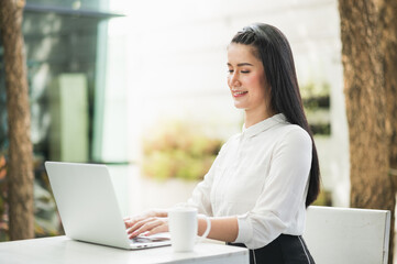 Beautiful asian woman work from home in the morning. Smiling charming happy young female stay at home.