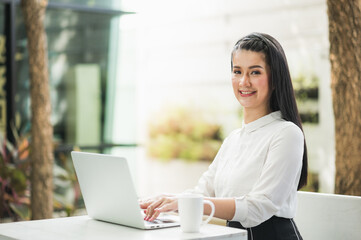 Beautiful asian woman work from home in the morning. Smiling charming happy young female stay at home.