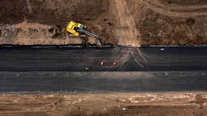 Aerial top down view of asphalting paving with commercial repair equipment road roller compactor machine. Heavy machinery. Ukraine, 2020