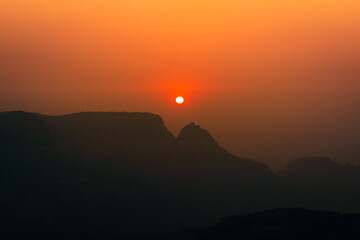 Spectacular silhouette view during sunset in Sahyadri mountain range on a winter evening from Sunset point at Matheran, Maharashtra, India.