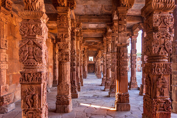 Columns with stone carving in courtyard of Quwwat-Ul-Islam mosque, Qutub Minar complex. It is...