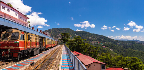 Toy train Kalka-Shimla route, standing on Shimla railway station with city in background. Shimla is state capital & tourist holiday destintation in the hill state Himachal Pradesh, India.