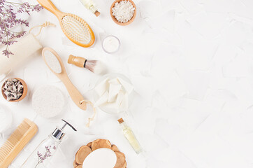 Elegant eco accessories for aromatherapy, massage with cosmetic products, perfume, essential oil, dry herbs on soft light white background, top view, border.