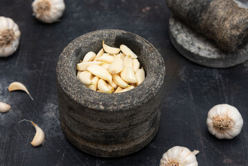 Ginger garlic paste with mortar and pestles homemade paste spicy herb ingredient of Thai Asian food. Fresh mashed Adrak and Lahsun on dark black background