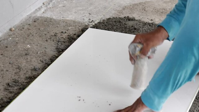 Installing tiles on the floor from a worker