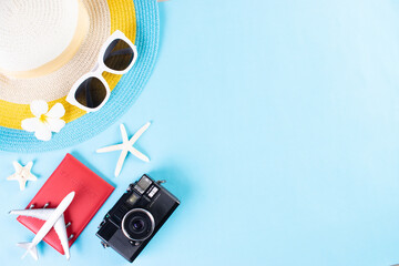 Beach hat, sunglasses, camera, passport and flip flop on light blue background.Summer or vacation...