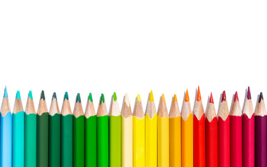 A row of multi-colored pencils on a white background with copy space. Bright stationery isoleted on white