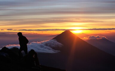 silhouette of a man on the top of the volcano at sunrise