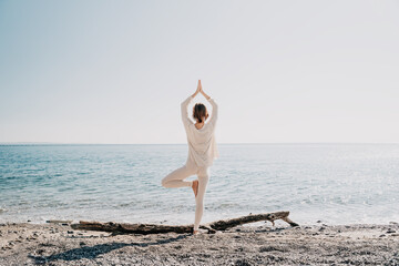 Woman practicing yoga on the beach