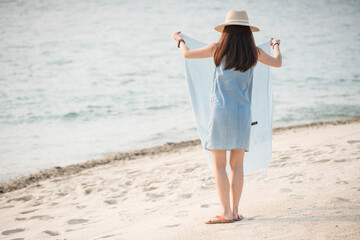 Woman laying cloth on the beach 