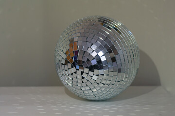Shining disco ball with a lot of sparkles on table in room as home decor. Cosy home concepr details