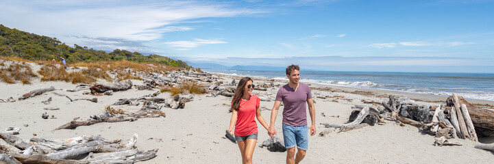 Panoramic banner of Couple walking on beach in New Zealand - people in Ship Creek on West Coast of...