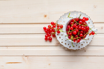 Fresh red currants in a cup on wooden table close up.Ripe large organic red currant .Summer fresh berries.agriculture and food concept