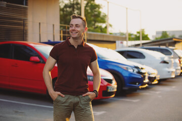 Rich and successful man in brown polo at the parking have a big car collection