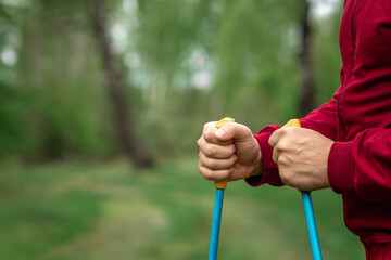 Nordic walking, sticks, hands close-up. The concept of a healthy lifestyle, cardio training. Copyspace.