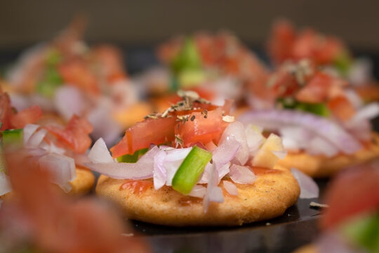 Monaco Biscuit With Sliced Capsicum ,tomatoes And Origano On Top Of It