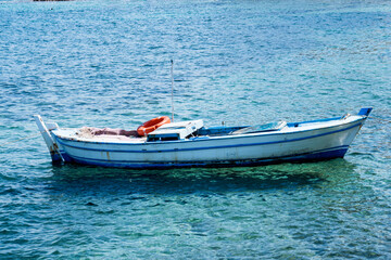 Naklejka na ściany i meble Small fishing boat in the sea 