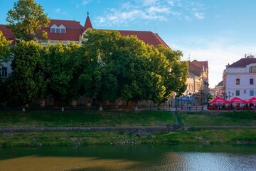 Obraz premium UZHHOROD, UKRAINE - JUN 04, 2017. beautiful sunny morning in uzhgorod. embankment of the river uzh in summertime