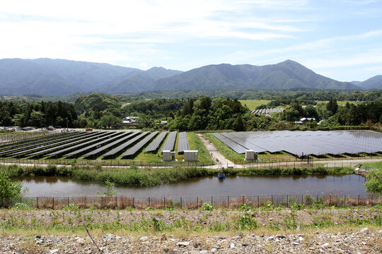 Solar cell panels and villages in rural areas with a background of mountain landscapes in Inabe City, Mie Prefecture, Japan