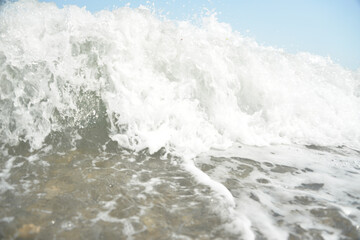 average waves on the sea reach the shore with foam and crash on the rocks with a noise